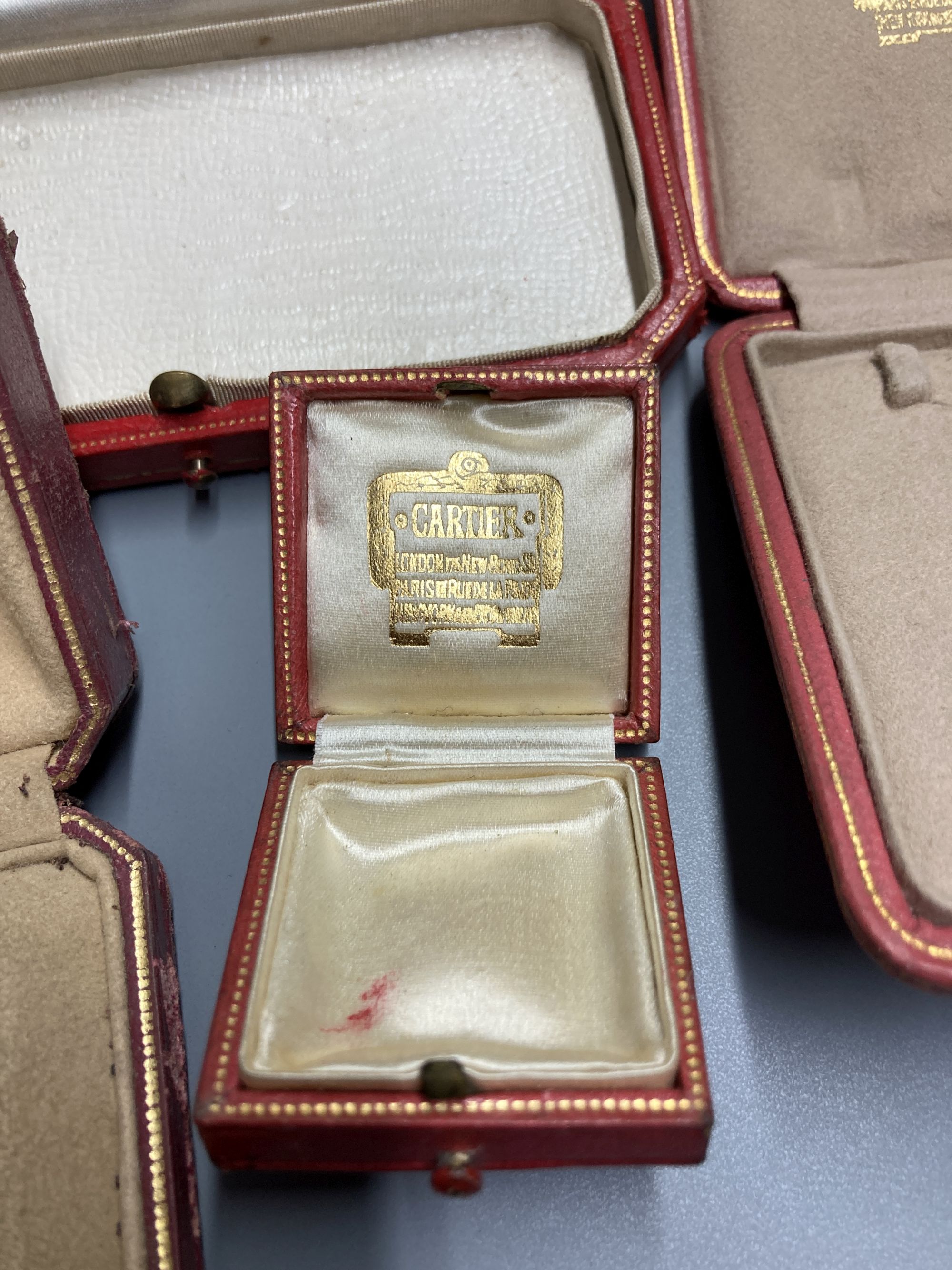 Five assorted Cartier gilt tooled leather jewellery boxes, largest 13.5cm.